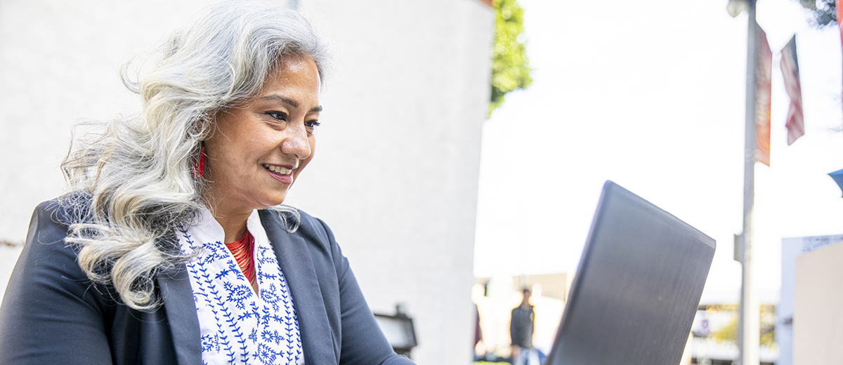 Woman in a business suit browsing on her laptop