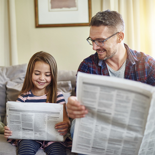 Father and daughter reading paper