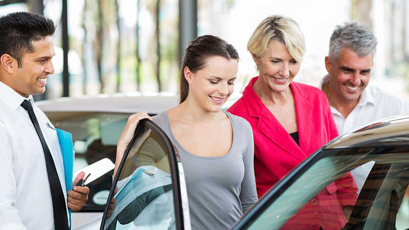 Family inspecting new car for sale