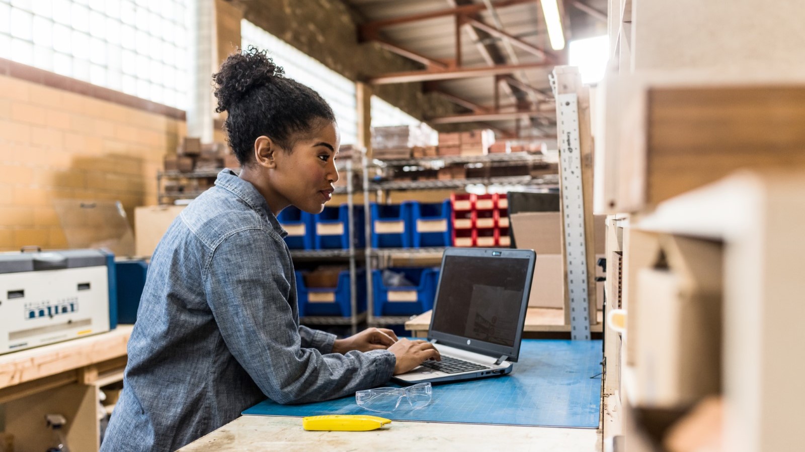 Person uses laptop in a manufacturing facility