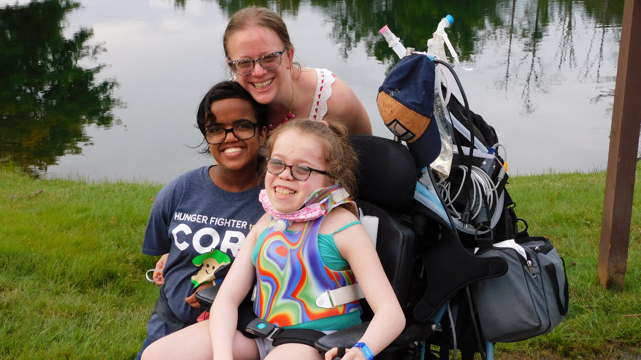 Heather Lee and two daughters smiling near a pond