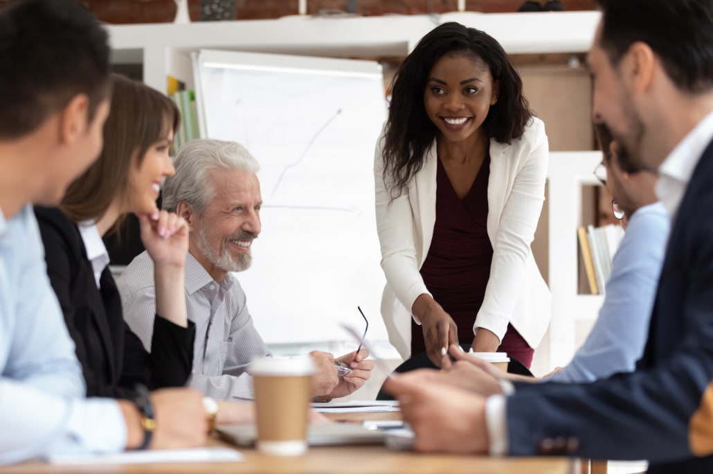 Six people around an office table having a meeting.