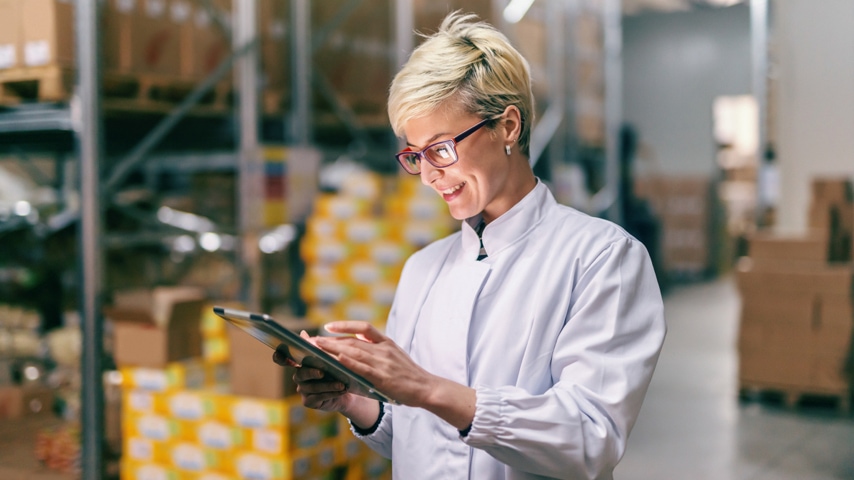 Person looking at a mobile device in a warehouse setting