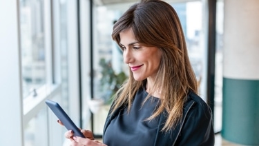 Person holding a tablet in both hands while looking at it