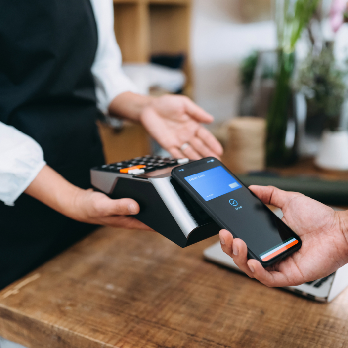 Customer tapping their phone to pay at a store.