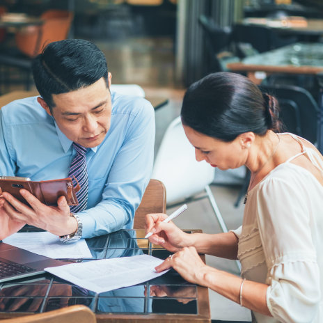 Man and woman reviewing and signing documents