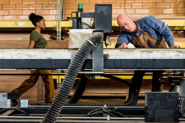 A man working on a large industrial machine in a factory.