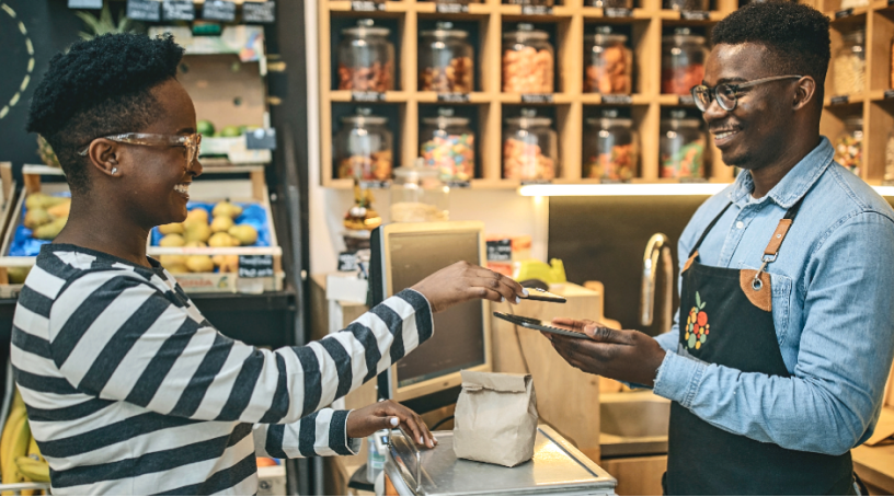 Customer at a grocery store paying the clerk.