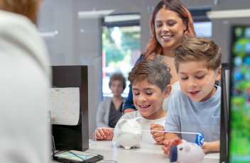 Woman with two children at the bank teller counter