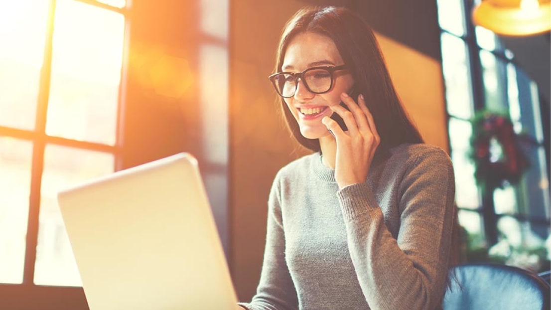 Woman browsing the internet and talking on a cell phone.