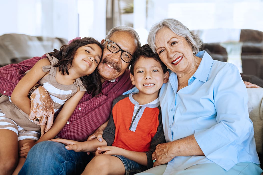 Familia sonriente sentada en un sillón