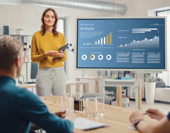 Woman in a meeting room giving a presentation to coworkers.